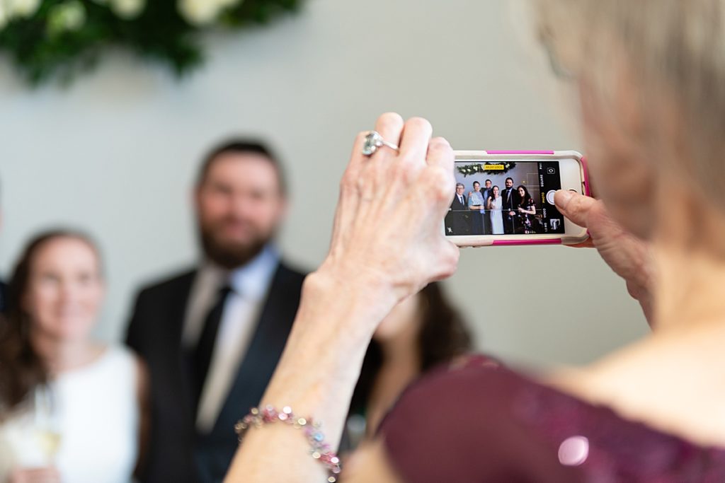 Woman photographing bride with her cell phone
