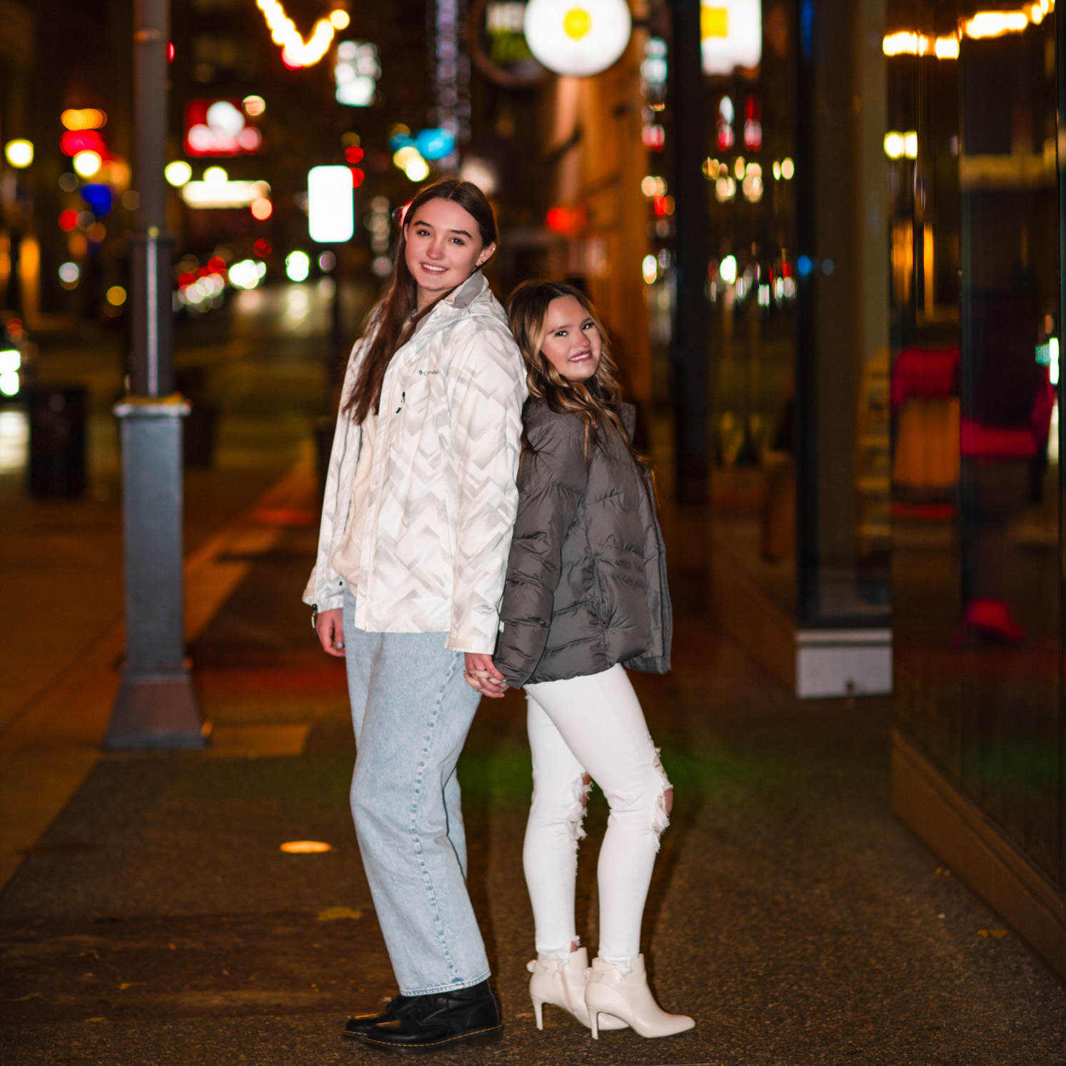 Night Photos of two teen girls on a lighted street in downtown Pittsburgh.